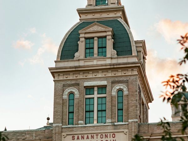 A historic brick building with a green domed roof and arched windows, bearing the inscription &ldquo;SAntonio Brevoqass n&rdquo; (likely misread) on the facade.