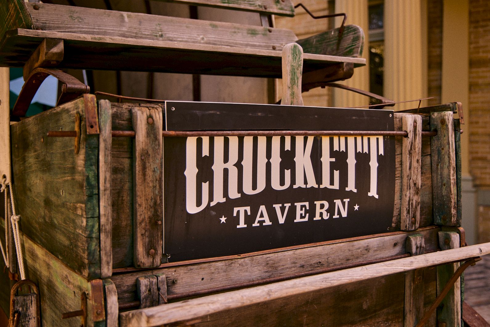 An old wooden crate with a sign reading &ldquo;CRUNKHETT TAVERN&rdquo; in bold letters.